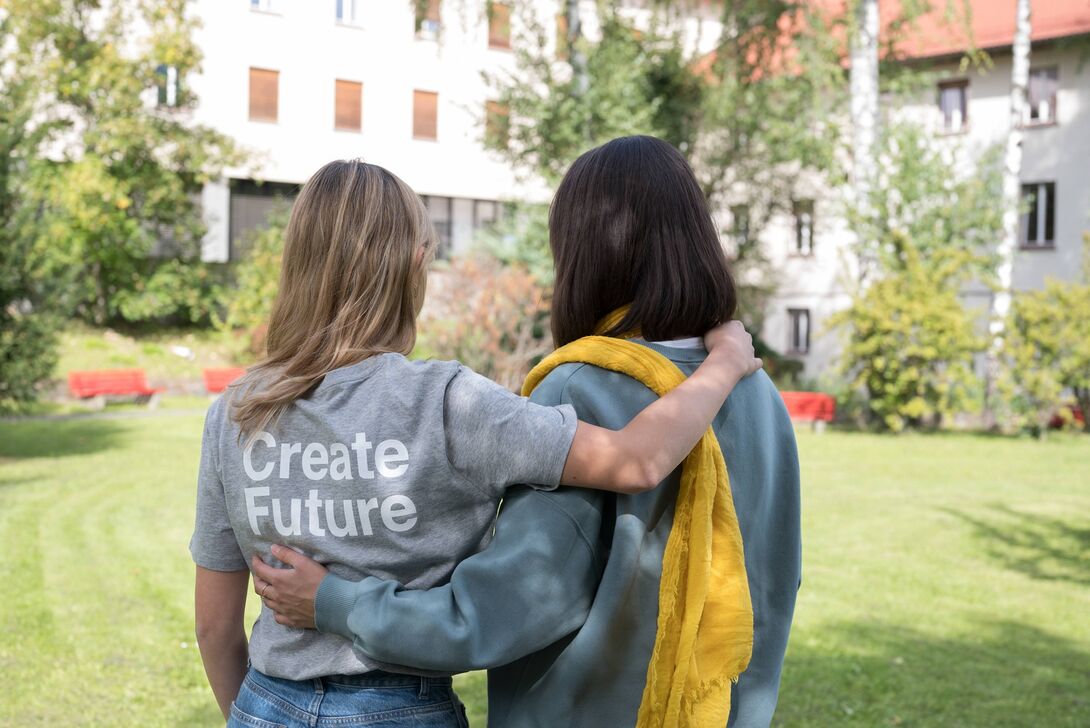 2 Personen von hinten Arm in Arm mit Create Future Tshirt