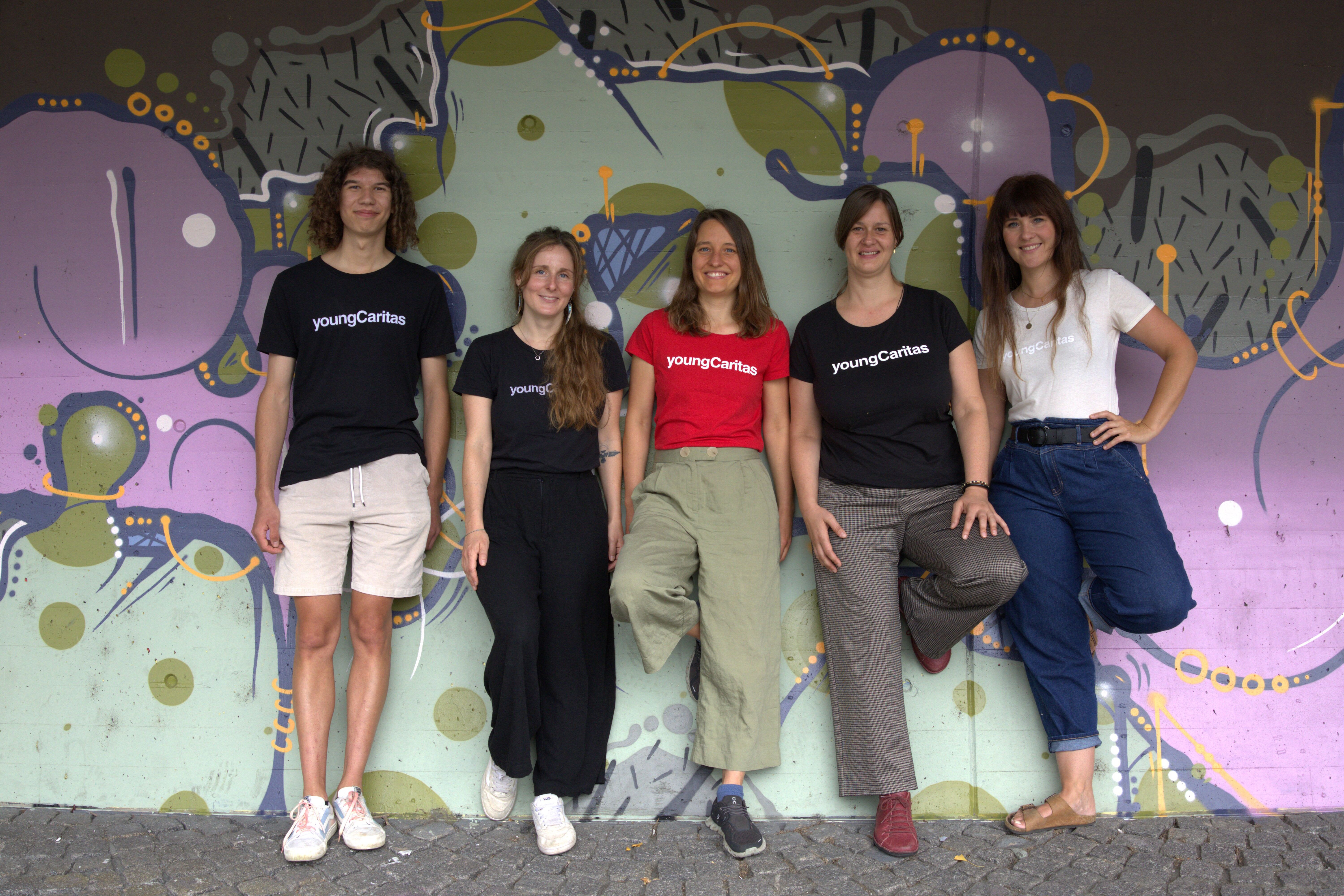 Foto von youngCaritas Tirol Team vor Graffitiwall