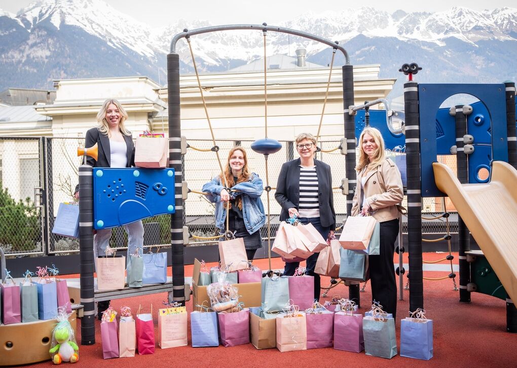 Foto von Lehrlingen der Raiffeisenbank Tirol mit Geschenksackerln für Kinder der Kinderherzklink